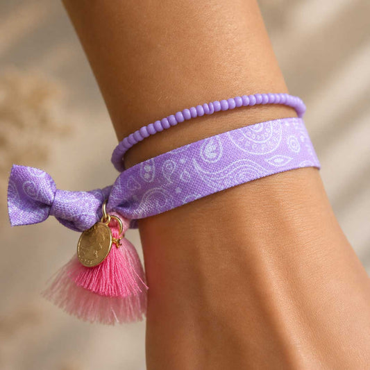Elastisches Armband-Set Lavender Paisley mit Paisley-Band und Perlenarmband am Handgelenk getragen – pinke Quaste mit goldenem Anhänger, Saltyblush