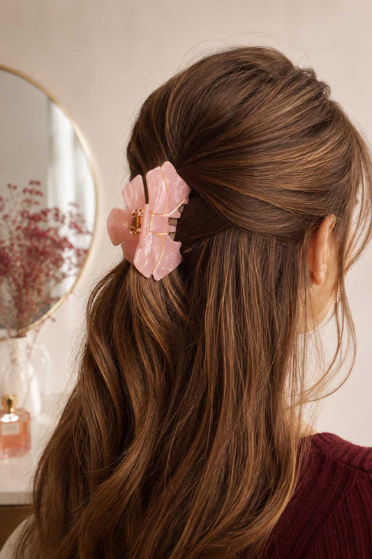 Aurabow Haarklammer getragen im braunen Haar – rosa Blütenklammer im Half-Up-Style mit goldenen Akzenten