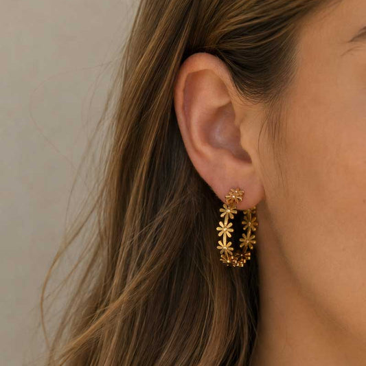 Golden Daisy goldene Gänseblümchen-Creolen am Ohr getragen mit weißem Pullover – Saltyblush