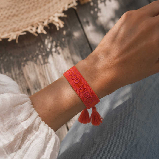 Good Vibes Armband in Orange mit roten Quasten am Handgelenk – Sommer Statement Schmuck Damen, Saltyblush