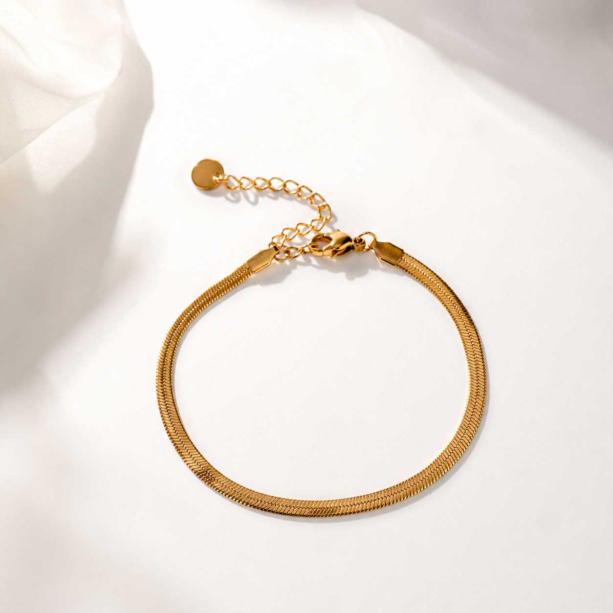 Goldenes Schlangenketten-Armband silk chain mit Karabinerverschluss auf weißem Hintergrund – Edelstahl, wasserfest | Saltyblush