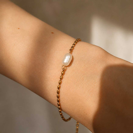 Goldenes Armband Pearl Tide mit Barockperle am Handgelenk getragen – Saltyblush
