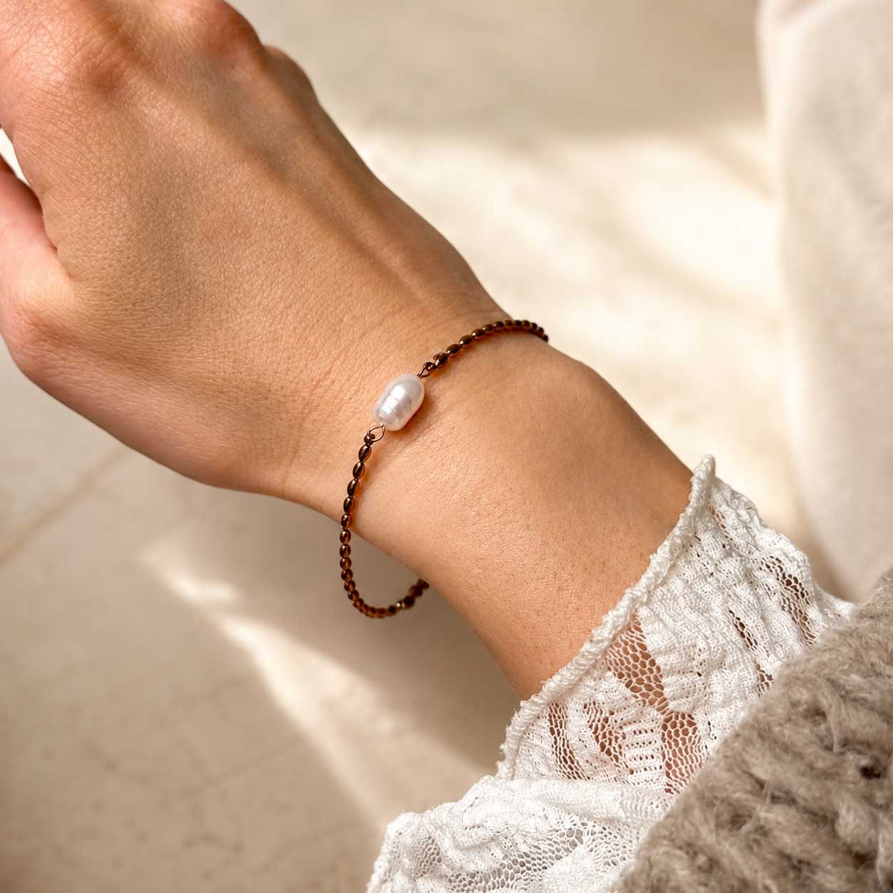 Goldenes Armband Pearl Tide mit weißer Perle am Handgelenk mit weißem Spitzenärmel – Saltyblush

