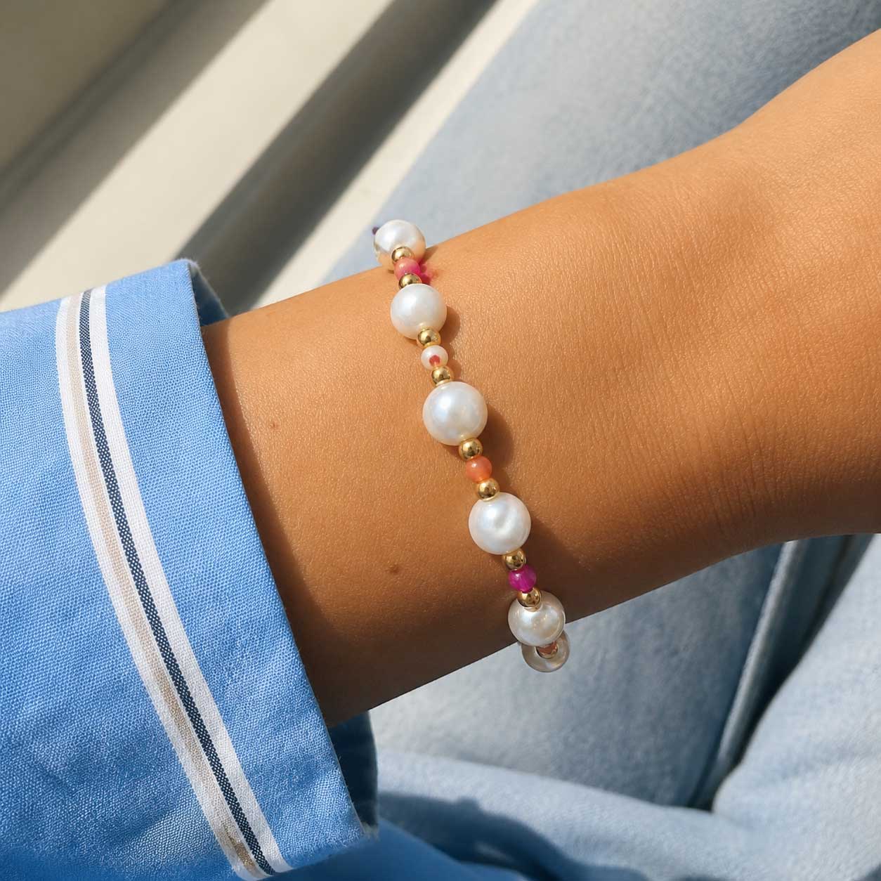 Goldenes Perlenarmband Candy Pearl mit weißen Perlen und pinken Kristallen am Handgelenk – Saltyblush

