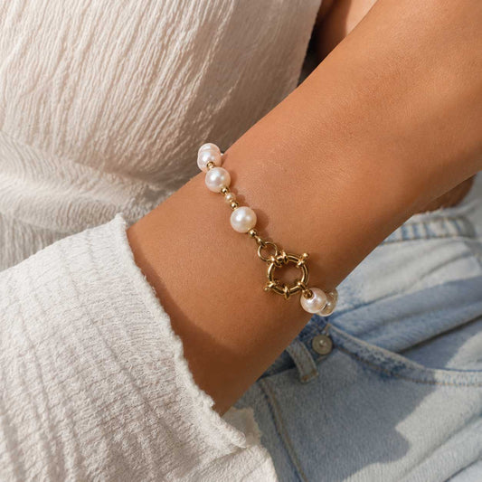 Goldenes Perlenarmband Pearl Glow mit weißen Perlen am Handgelenk getragen – Edelstahl, Saltyblush
