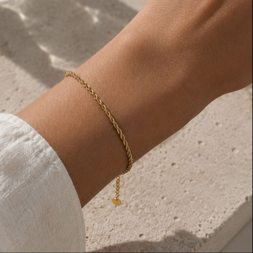 Goldenes Twist-Armband Soft Twist am Handgelenk auf Stein – Edelstahl, Saltyblush
