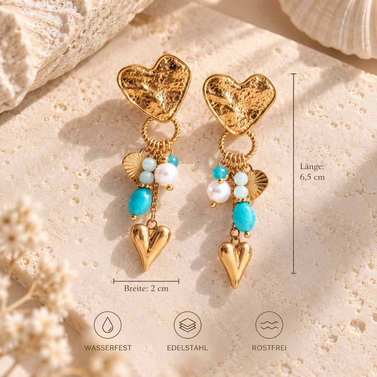 Goldene salty heart Ohrringe mit Herz- und Perlenanhängern. Maßangaben: 6,5 cm Länge und 2 cm Breite; Bildhinweise zu Edelstahl, Wasserfestigkeit und Rostfreiheit.
