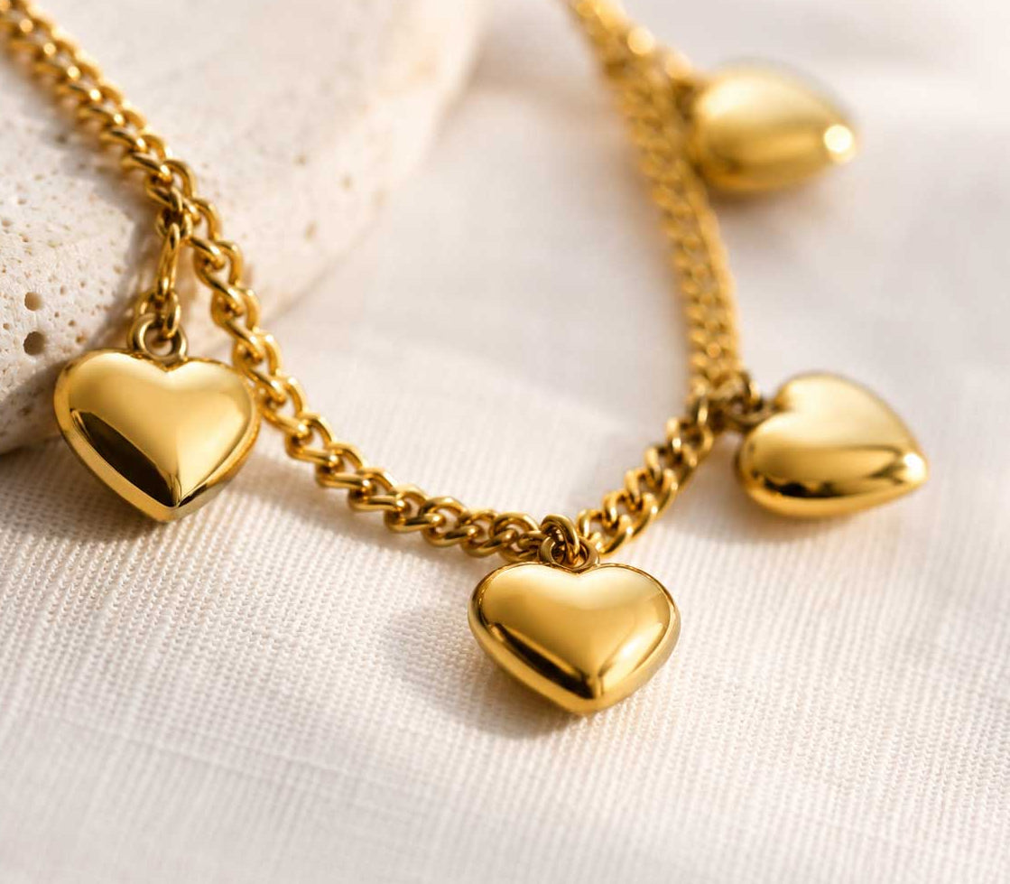 Nahaufnahme goldene Herzcharms – Golden Hearts Armband von Saltyblush, glänzende 3D-Herzen an feiner Goldkette, Detailansicht
