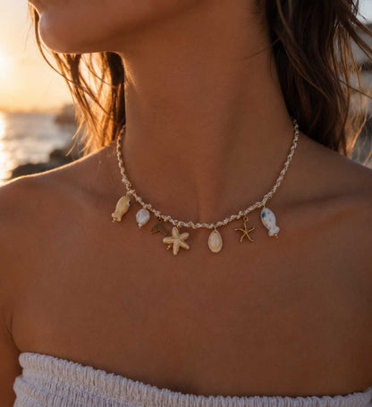 Salty Star Halskette Lifestyle Sonnenuntergang – maritime Charm-Kette von Saltyblush am Hals einer Frau, Seestern- und Fisch-Charms im goldenen Abendlicht am Strand
