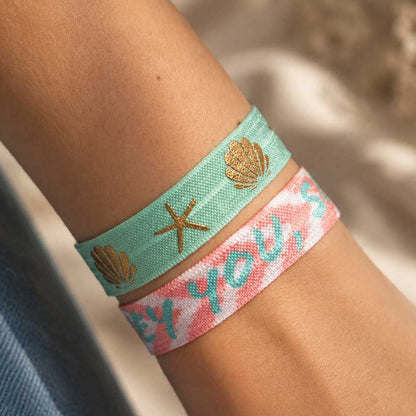 Elastisches Armband-Set Ocean Breeze – mintgrünes Muschel-Seestern-Band und rosa „HEY YOU,SMILE"-Band kombiniert am Handgelenk, Strandlook – Saltyblush
