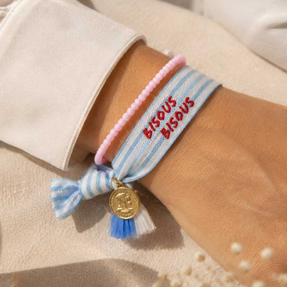 Elastisches Armband-Set Bisous Bisous mit hellblau-weißem Streifenband und rosa Perlenarmband am Handgelenk – blaue Quaste mit goldenem Münzanhänger, Strandlook – Saltyblush
