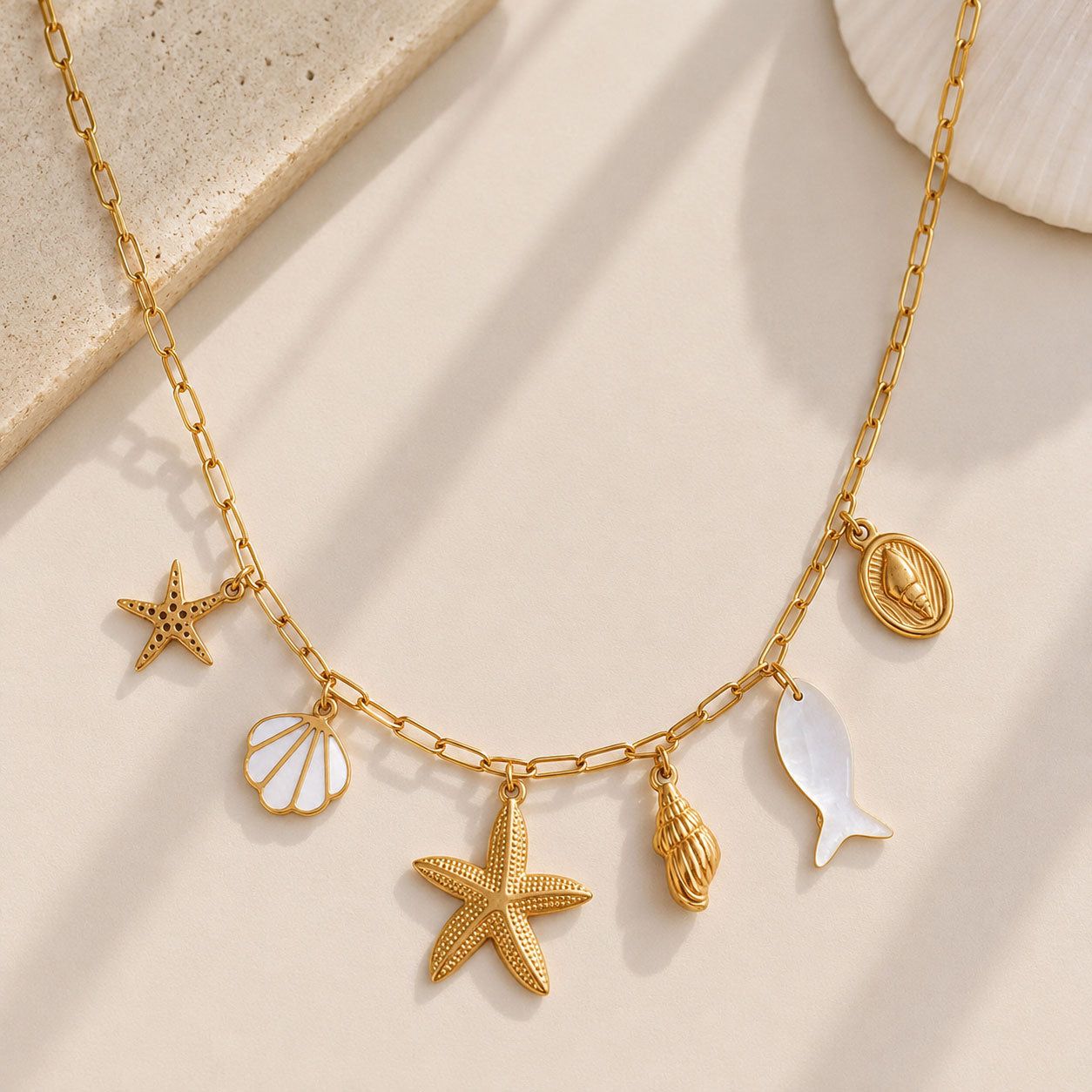 Goldene Halskette Ocean Treasures mit Seestern, Muschel, Schnecke, Fisch und Perlmutt-Charms – Saltyblush
