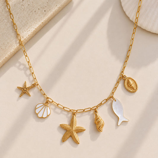 Goldene Halskette Ocean Treasures mit Seestern, Muschel, Schnecke, Fisch und Perlmutt-Charms – Saltyblush
