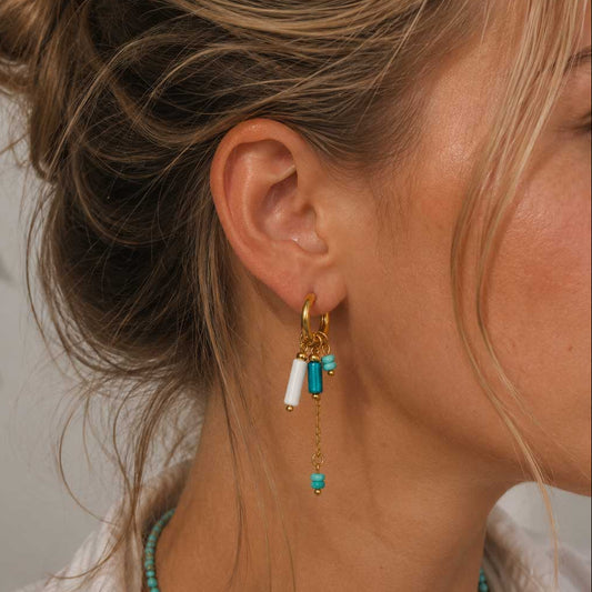 Goldene Creolen Blue Tide mit türkisen Perlen-Charms am Ohr getragen – Saltyblush
