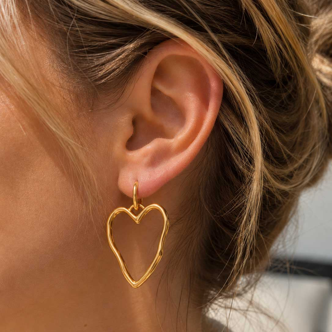Goldene Herz-Ohrringe Heartline am Ohr getragen – Edelstahl, Saltyblush

