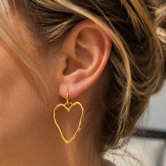 Goldene Herz-Ohrringe Heartline am Ohr getragen – Edelstahl, Saltyblush
