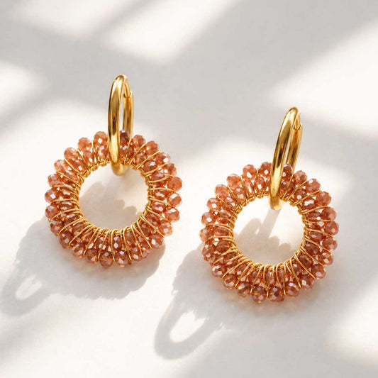 Goldene Creolen Mokka Glow Hoops mit terrakottafarbenen facettierten Glasperlen auf weißem Hintergrund – Edelstahl, Saltyblush
