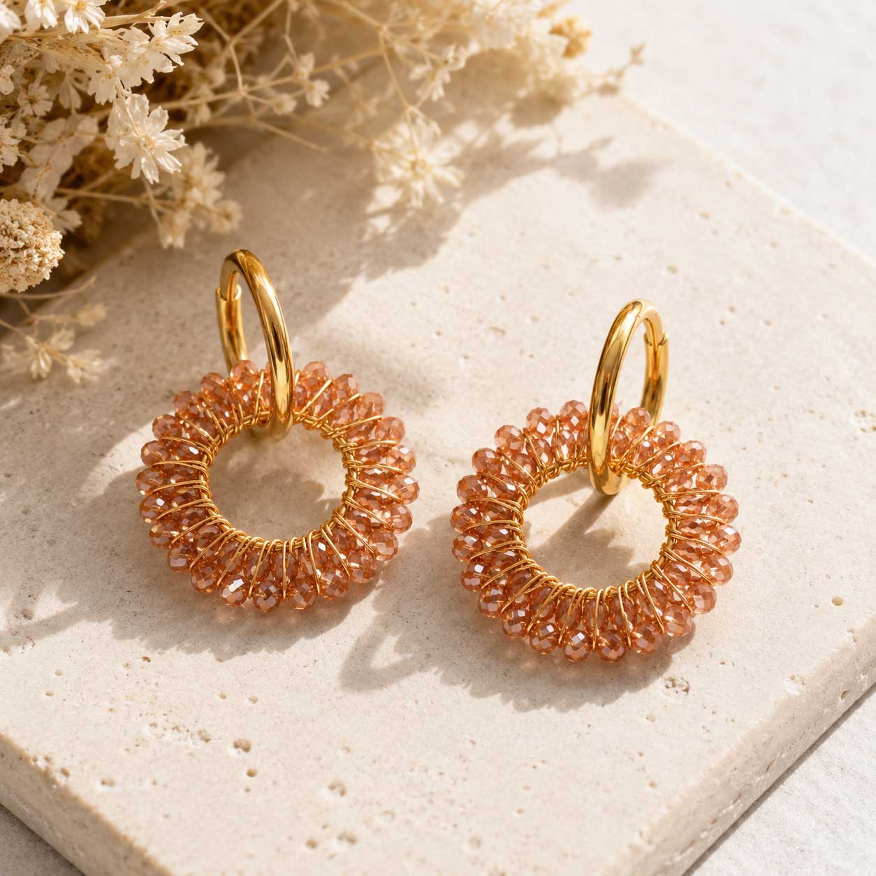 Goldene Creolen Mokka Glow Hoops mit terrakottafarbenen facettierten Glasperlen auf Travertinstein mit Trockenblumen – Edelstahl, Saltyblush
