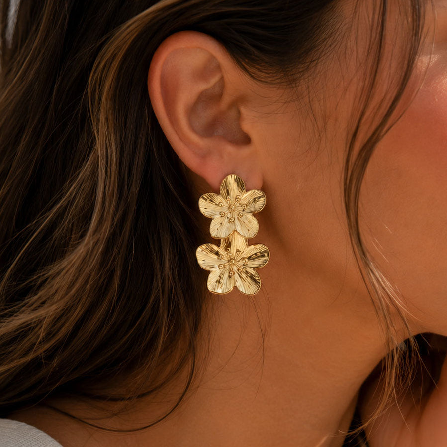 Goldene Ohrstecker Golden Blossom mit Doppelblüten-Anhänger am Ohr getragen – Edelstahl, Saltyblush
