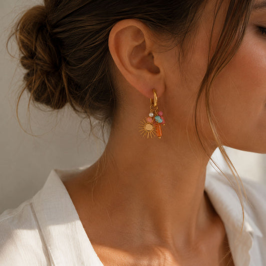 Goldene Creolen Golden Sun mit Sonnen-Charm und Pastellperlen am Ohr getragen – Edelstahl, Saltyblush

