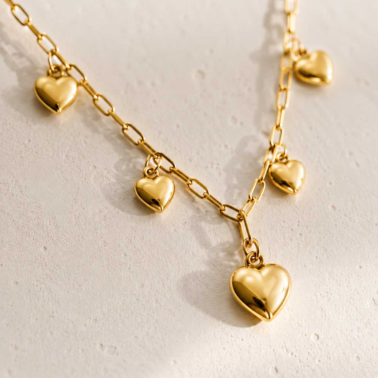 Goldene Halskette Amour Glow – Detailansicht der Herz-Charms an Gliederkette, Edelstahl, Saltyblush

