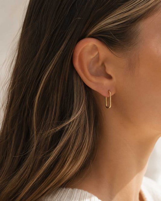 Bare Glow goldene rechteckige Creolen am Ohr getragen mit offenem braunem Haar – Saltyblush
