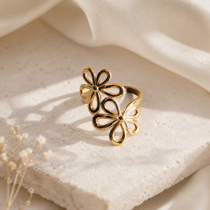 Blossom Glow Ring – goldener Blütenring mit offenen Blütenformen auf hellem Stein, Edelstahl, Saltyblush