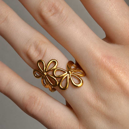 Blossom Glow Ring Nahaufnahme am Finger – goldener Doppelblüten-Ring, filigrane offene Blütenstruktur, Edelstahl, Saltyblush