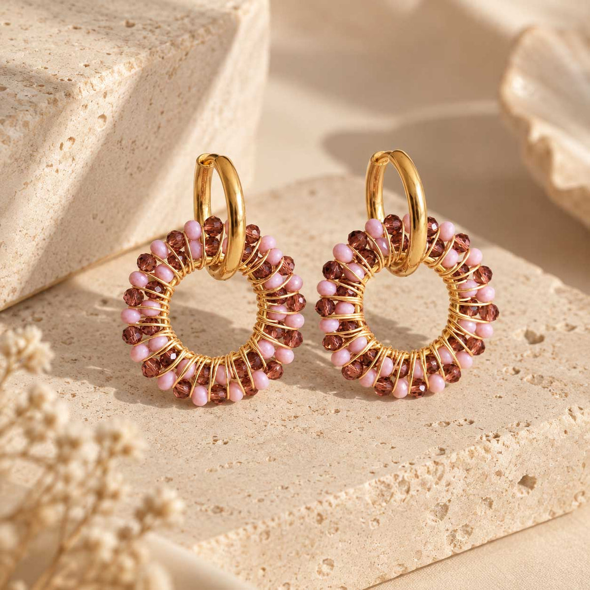 Blush Beaded Hoops – goldene Creolen mit rosa und burgunderroten Kristallperlen auf golddraht-gewickeltem Ring, auf Naturstein

