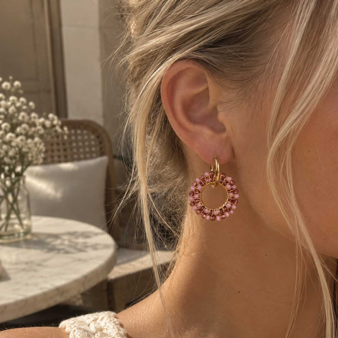 Blush Beaded Hoops goldene Creolen mit rosa Perlenring am Ohr getragen, helles Interior-Lifestyle-Foto
[AI]
