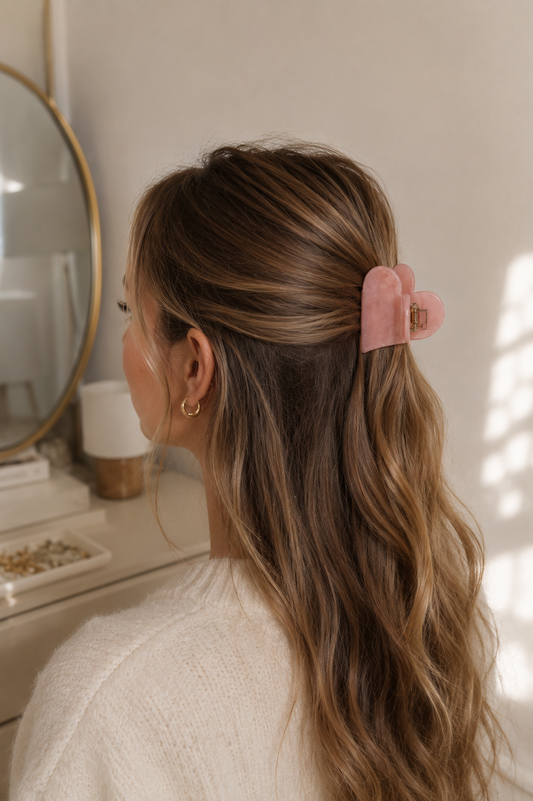 Frau mit langen braunen Haaren trägt rosa herzförmige Haarklammer im Half-Up-Style – Lifestyle-Aufnahme – Saltyblush
