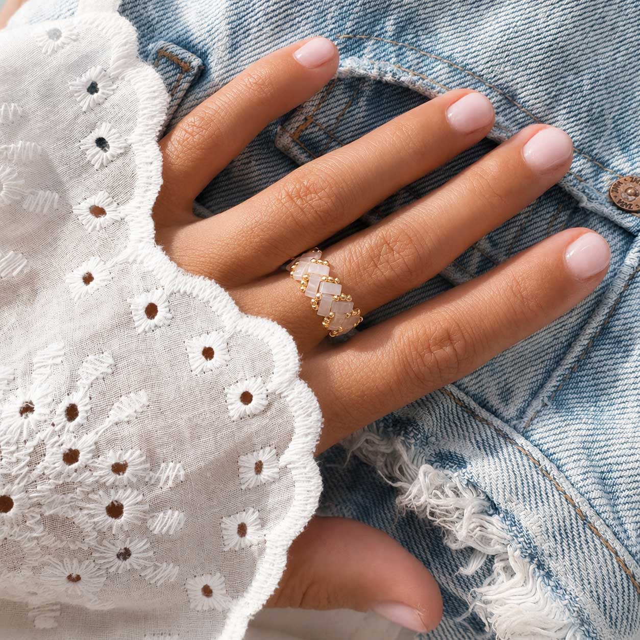 Hellrosa Miyuki-Perlenring mit goldenen Rocailles in Zickzack-Flechtmuster, handgefertigter Beaded Ring in Rosa-Gold auf weißem Hintergrund
