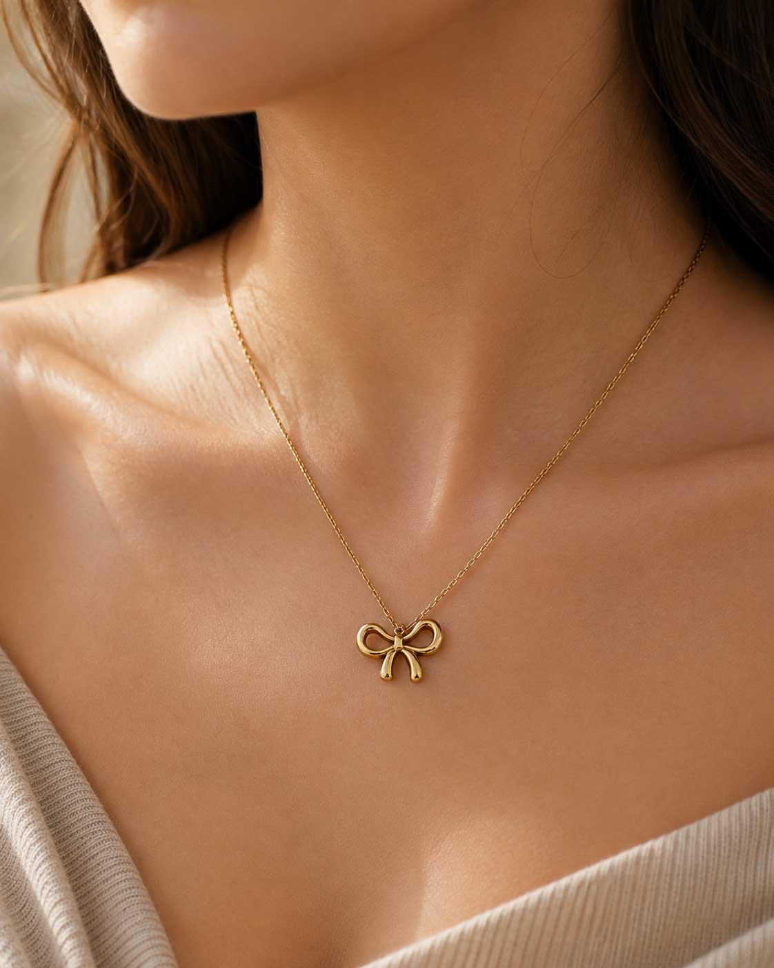 Frau trägt goldene Schleifenkette Bow Glow von Saltyblush – minimalistisches Statement-Piece für Alltag & besondere Anlässe
[AI]
