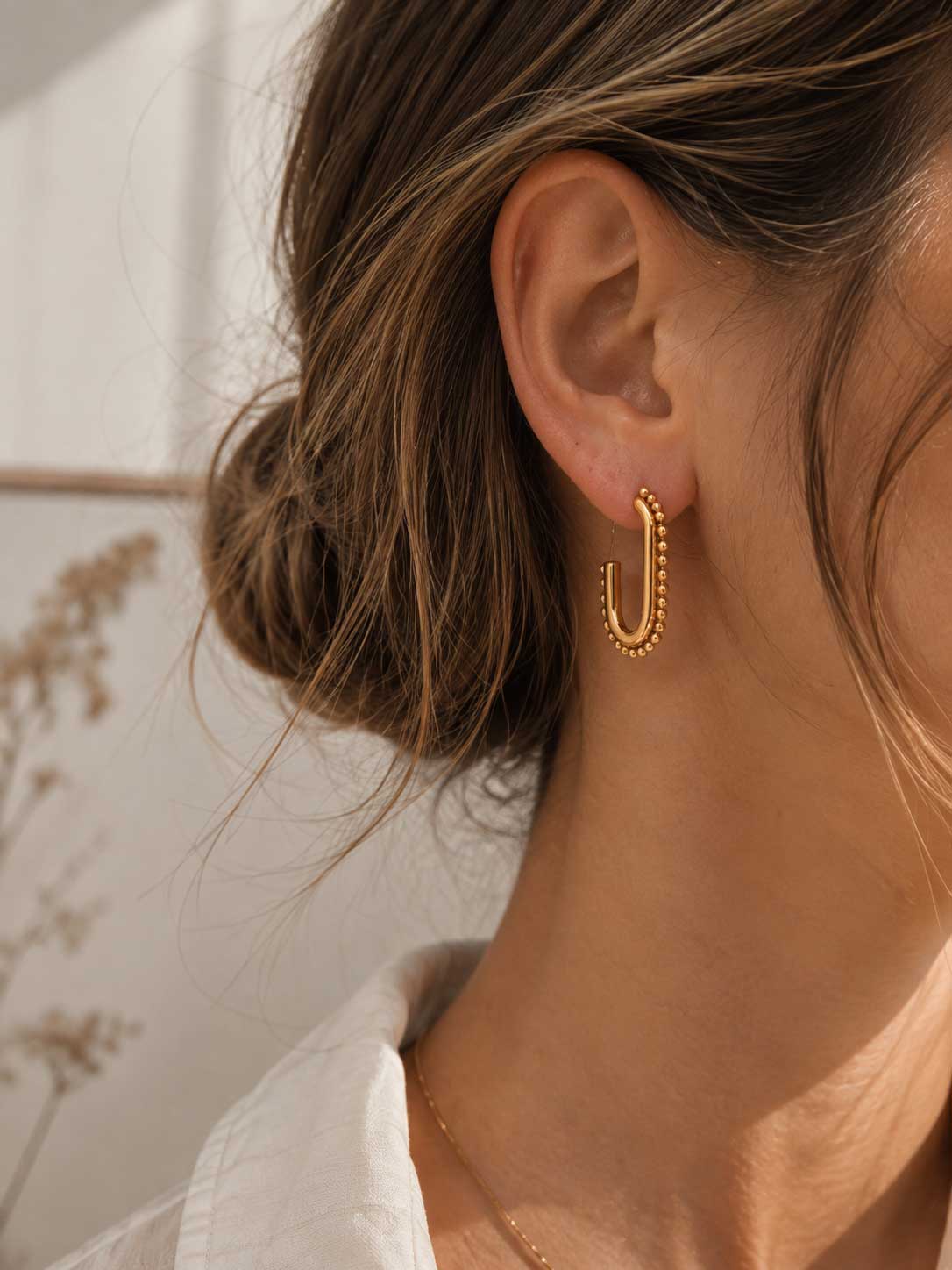 Celeste Glow goldene rechteckige Ohrringe getragen – elegante Seitenansicht mit Halskette
