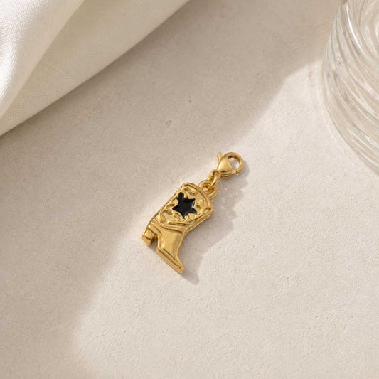 Cowboy Boot Charm aus Edelstahl in Gold mit schwarzem Stern-Detail und Karabinerverschluss auf hellem Steinhintergrund – Saltyblush
