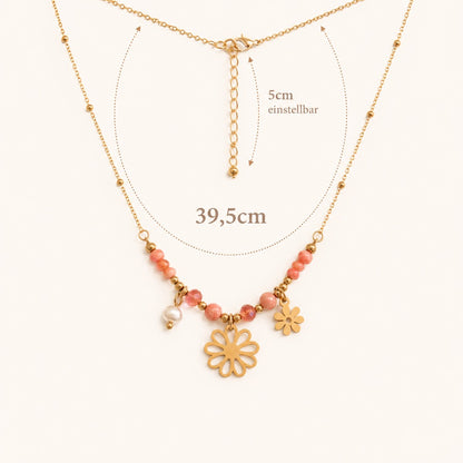 Flower Power Halskette Infografik – goldene Satellitenkette mit rosa Perlen und Blumen-Charms, Länge 39,5 cm, 5 cm einstellbar, Karabinerverschluss auf cremefarbenem Untergrund
