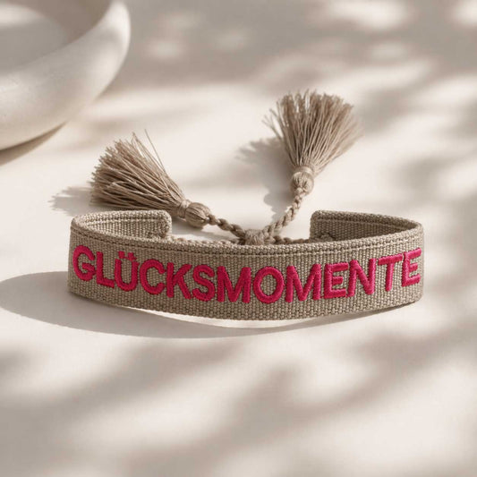 Glücksmomente Statement Armband in Grau mit pinkem Schriftzug und Quasten – gewebtes Arm
