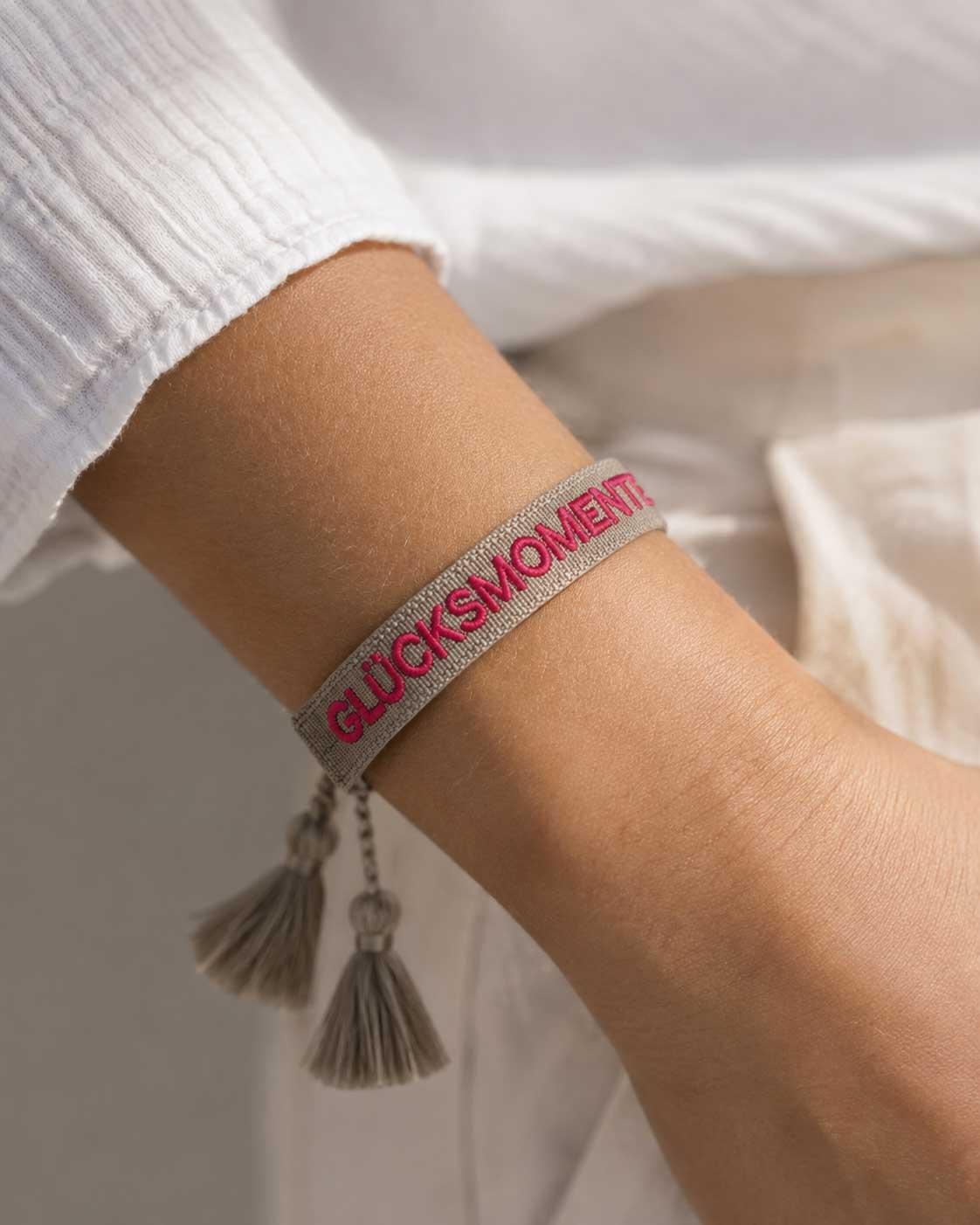 Graues Statement Armband Glücksmomente mit pinker Stickerei und Quasten am Handgelenk – Saltyblush

