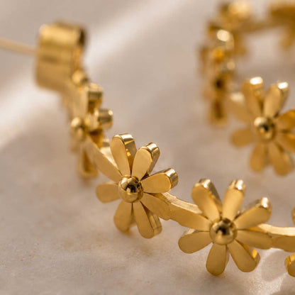 Nahaufnahme goldener Gänseblümchen-Creolen mit detaillierter Blütenstruktur aus Edelstahl – Golden Daisy von Saltyblush
