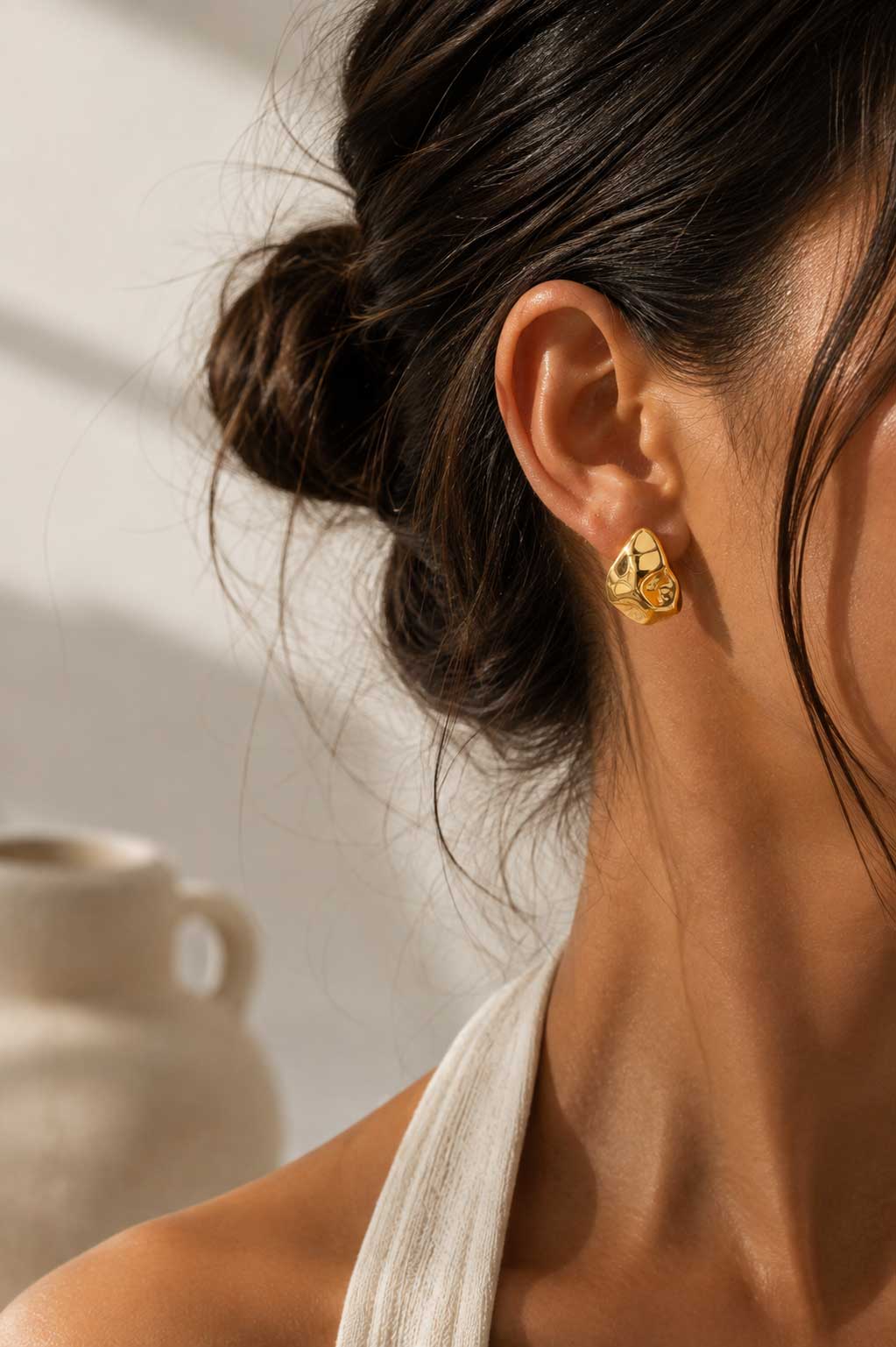 Frau mit hochgestecktem Haar trägt goldene Drop Ohrstecker aus Edelstahl – elegante Lifestyle-Aufnahme – Saltyblush
