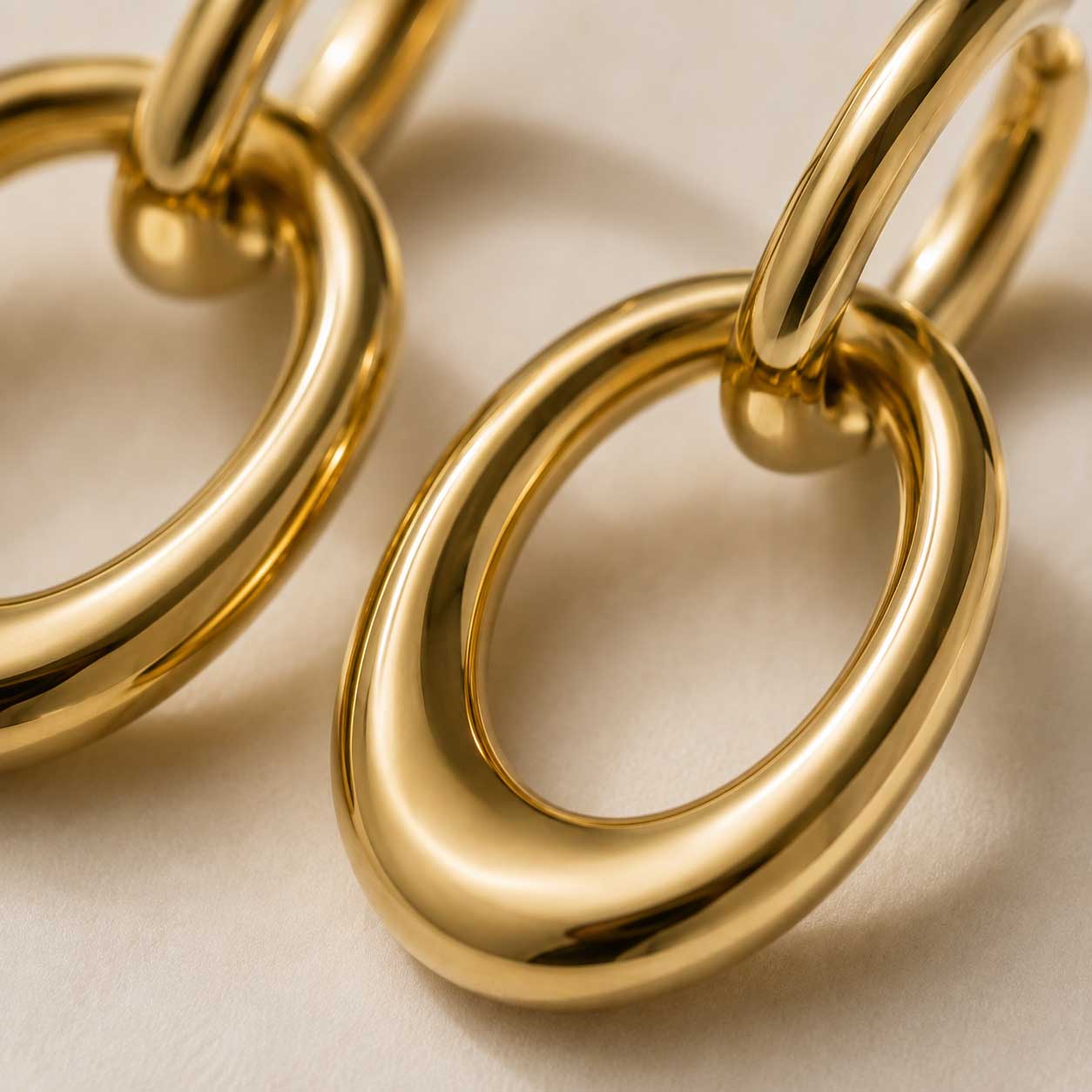 Nahaufnahme goldener Double-Ring Ohrringe mit glänzender Oberfläche aus Edelstahl – Golden Flow von Saltyblush
