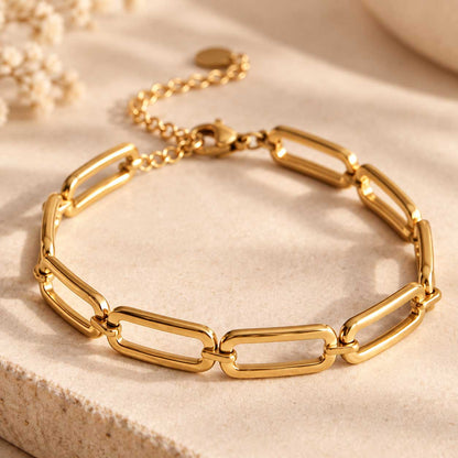 Detailaufnahme des goldenen Edelstahlarmbands mit klar geformten, offenen Gliedern und glänzender Oberfläche im minimalistischen Statement-Look
