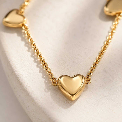 Nahaufnahme goldener Herzcharm – Golden Heart Halskette von Saltyblush, glänzender 3D-Herzanhänger an feiner Goldkette, Detailansicht
