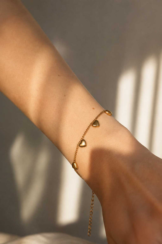 Golden Hearts Armband am Handgelenk – goldenes Herzarmband von Saltyblush, getragen, feminines Schmuckstück für den Alltag
