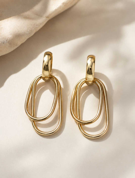 Goldene Ohrringe mit doppelten ovalen Ringen auf hellem Hintergrund – Golden Loop von Saltyblush
