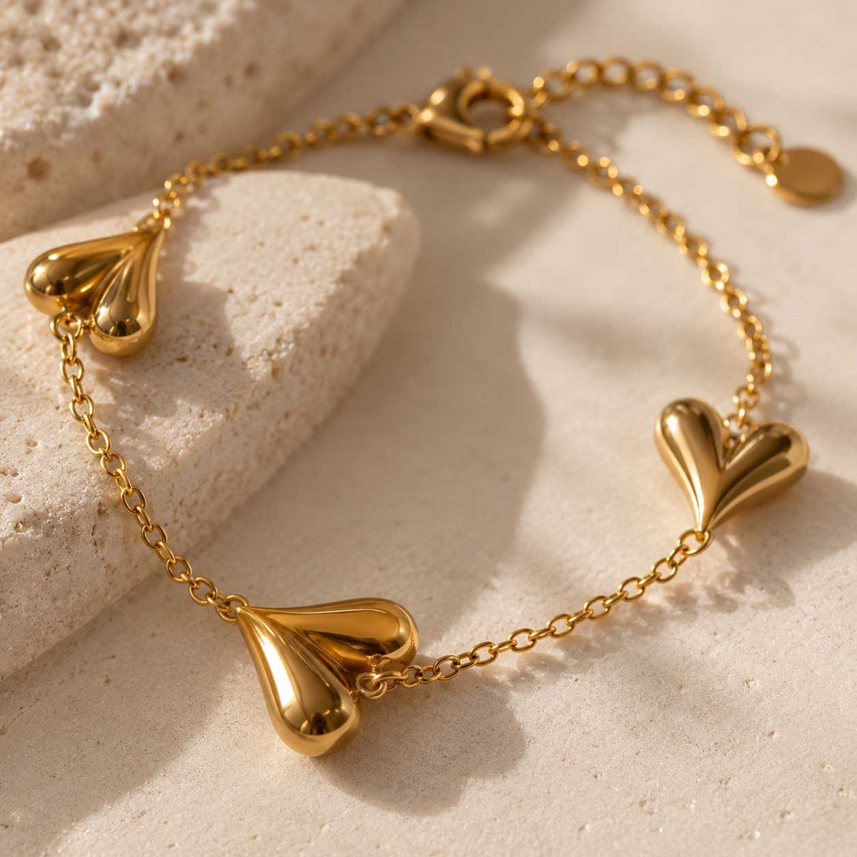 Nahaufnahme: drei filigrane Herzen an goldener Edelstahl-Kette, Armband golden love von Saltyblush
