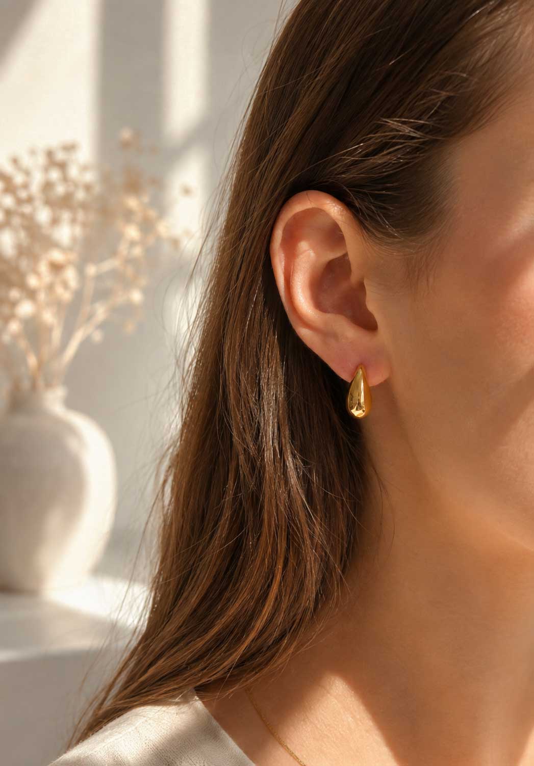 Golden Moon Ohrringe getragen – goldene Halbmond Stecker von Saltyblush am Ohr einer Frau mit braunem Haar, minimalistischer Look im Sonnenlicht
