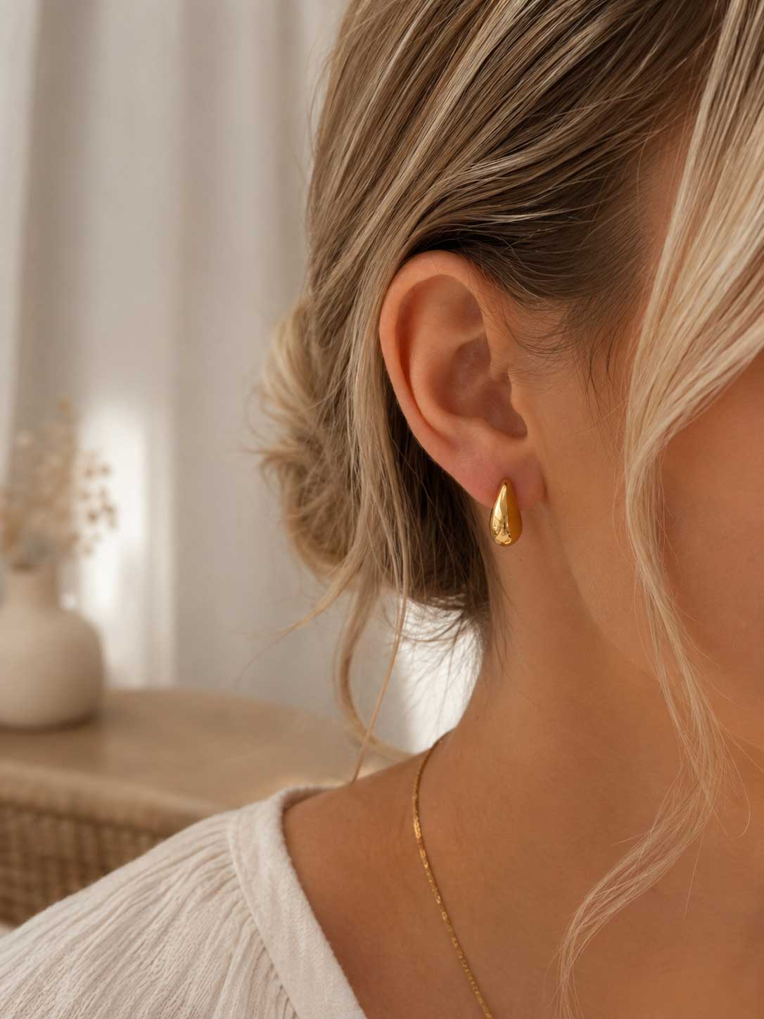 Golden Moon Ohrringe getragen – goldene Halbmond Stecker von Saltyblush am Ohr einer Frau mit blondem Haar, eleganter Look zu weißem Oberteil und goldener Halskette
