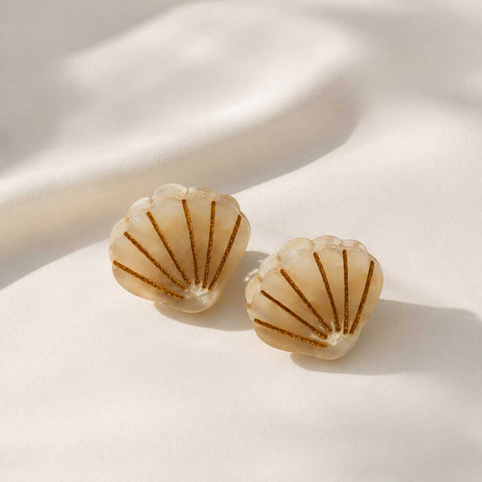 Haarklammern in Muschelform aus cremefarbenem Acryl mit goldenen Streifen auf weißem Seidenstoff – Golden Shell von Saltyblush
