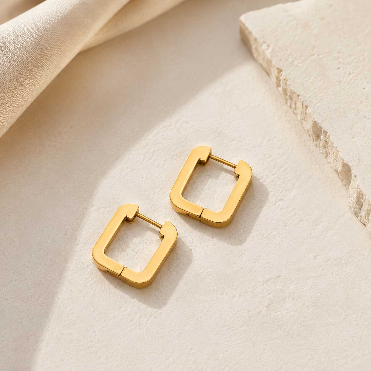 Goldene Square Ohrringe aus Edelstahl auf hellem Hintergrund – Saltyblush
